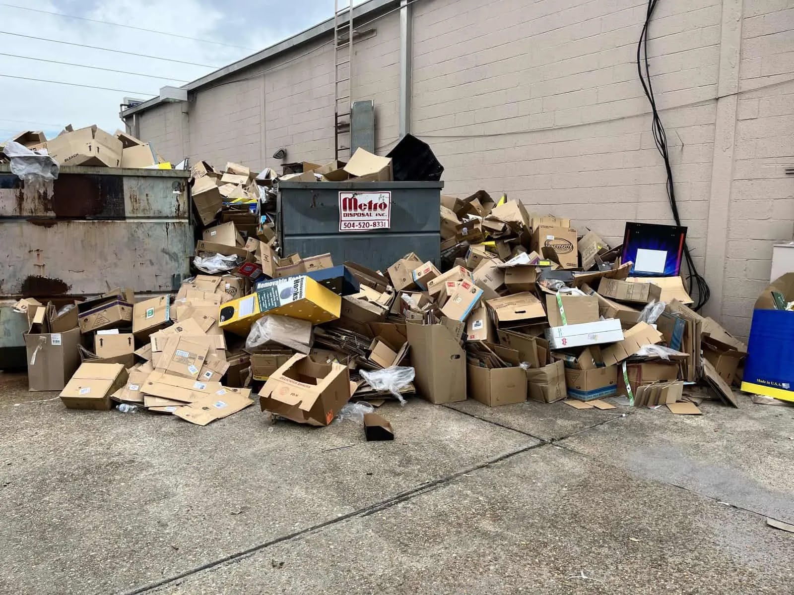 Pile of cardboard waste overflowing a dumpster after a typical move